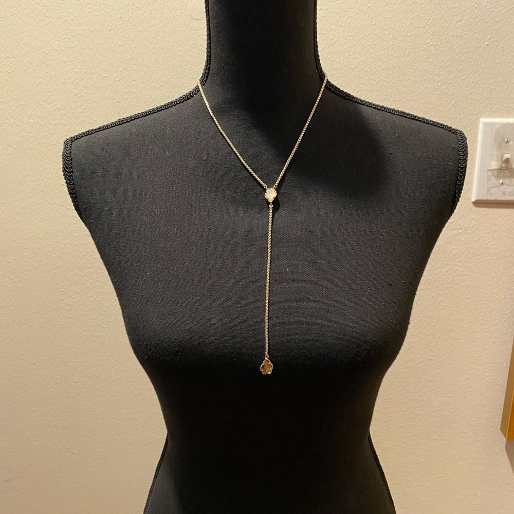 Kendra Scott gold colored necklace with two stones: white and light brown